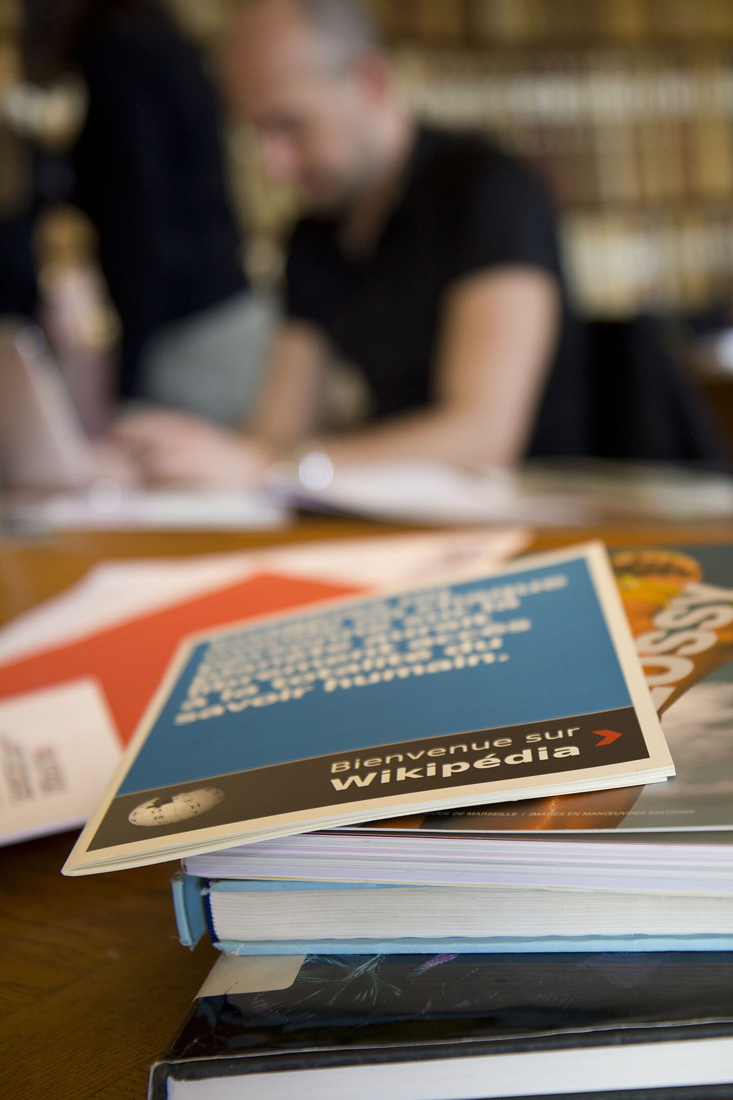 Un bureau avec un gros plan sur une brochure qui titre "Bienvenue sur Wikipédia"