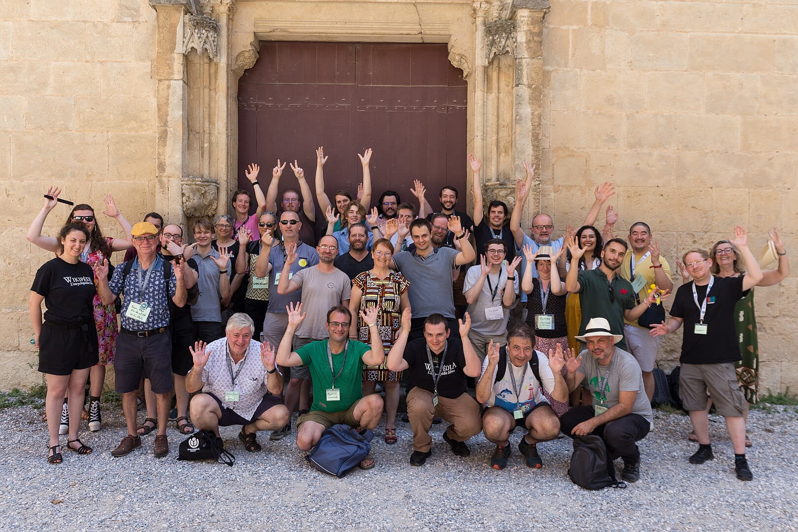 Photo de groupe de membres Wikimedia en extérieur, devant un mur